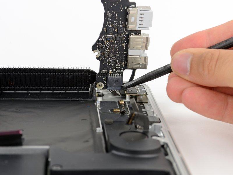 Using the flat end of a spudger, carefully push the MagSafe 2 connector out