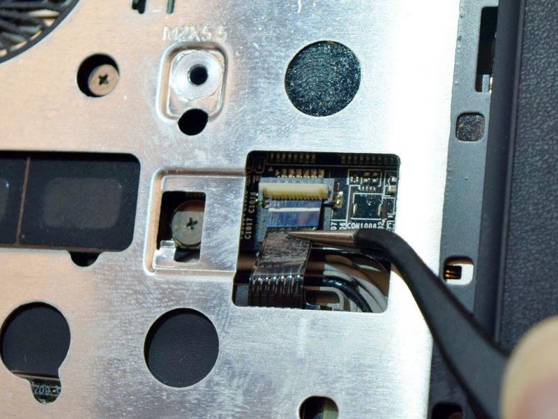 Ensure the bezel remains in place until the cables are disconnected. Flip the laptop back over.