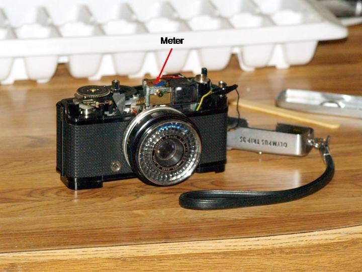 1. Remove the top of the camera. The top is held on with three screws. One is on the right side, just under the wrist strap lug. The other two are under the film rewind crank.