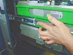 Remove cardboard support from mechanism cassettes. With 2-personnel, lift the NMD-50 by the green handles and align the rails on the dispenser with the slide rails.