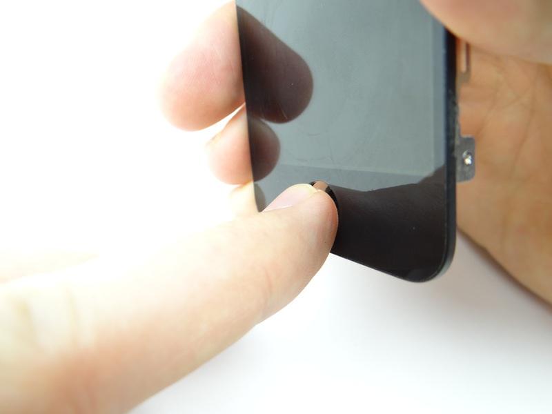 Step 20 The home button is held in place with mild adhesive. Use your thumb to push the home button away from the front panel.