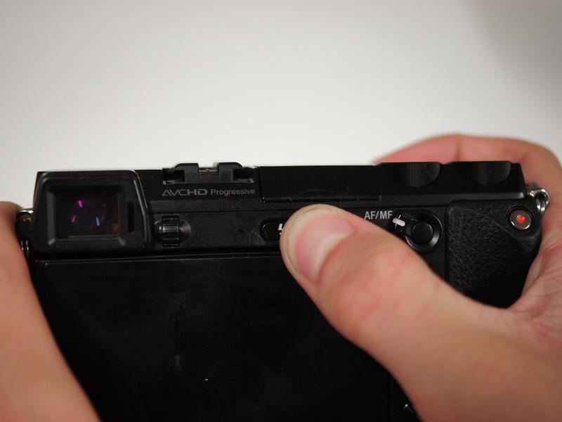 Step 10 Looking at the back of the camera, press the button with a