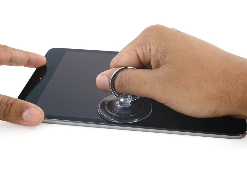 While holding the ipad down with one hand, pull up on the suction cup to slightly separate the front panel