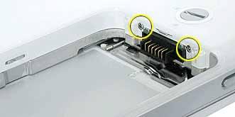6. Remove the two identical Phillips screws next to the battery connector. 7.