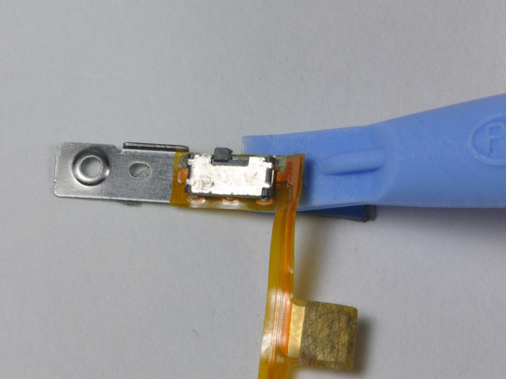 Step 31 Use the small ipod opening tool to carefully peel the orange ribbon cable and attached black Hold switch up from the metal backing.