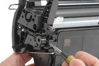 Remove the spring-loaded drum shutter arm using a small flat-blade screwdriver (See photo