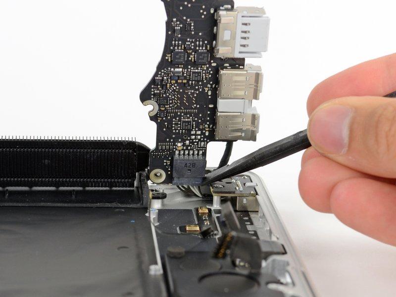Using the flat end of a spudger, carefully push the MagSafe 2 connector out of its socket on the bottom of the logic board. Disconnecting the MagSafe 2 connector can be difficult.