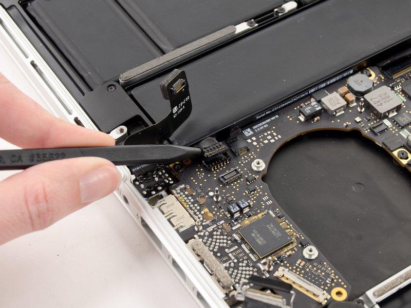 Gently pry the left speaker cable connector up off from its socket on the logic board.