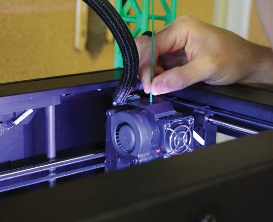 Take the end of the PLA Filament and firmly push it into the hole in the top of the extruder.
