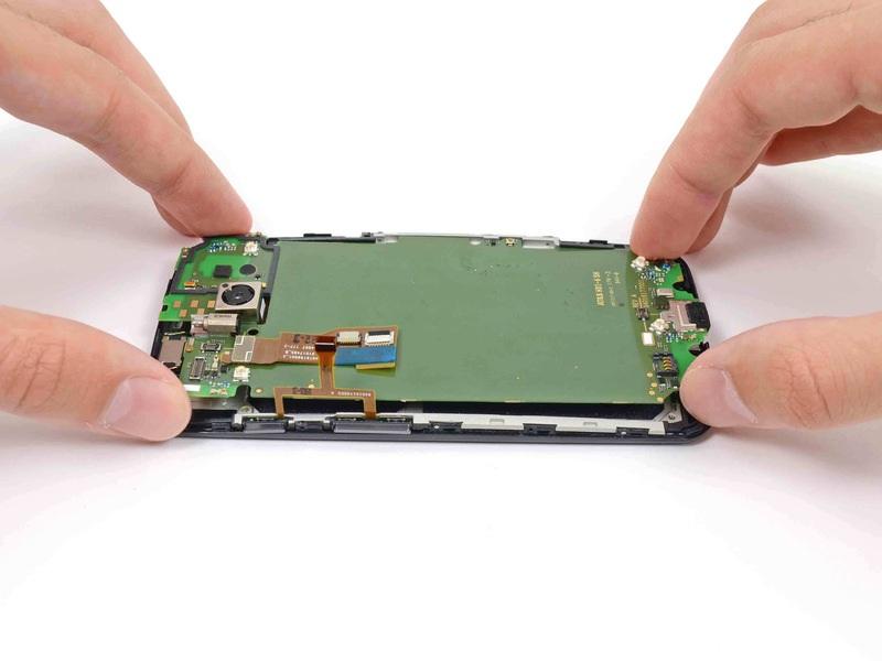 Step 26 Gently lift the motherboard out of the phone, rotating it from the SIM slot edge