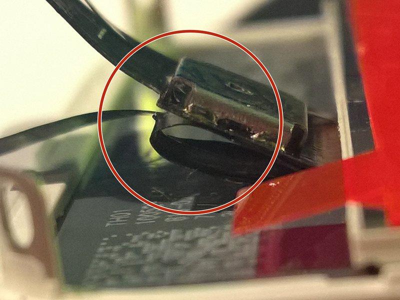 This photo shows the display assembly being installed incorrectly, with too much slack in the digitizer cable, which then forms a bend/loop that gets caught in the slot.