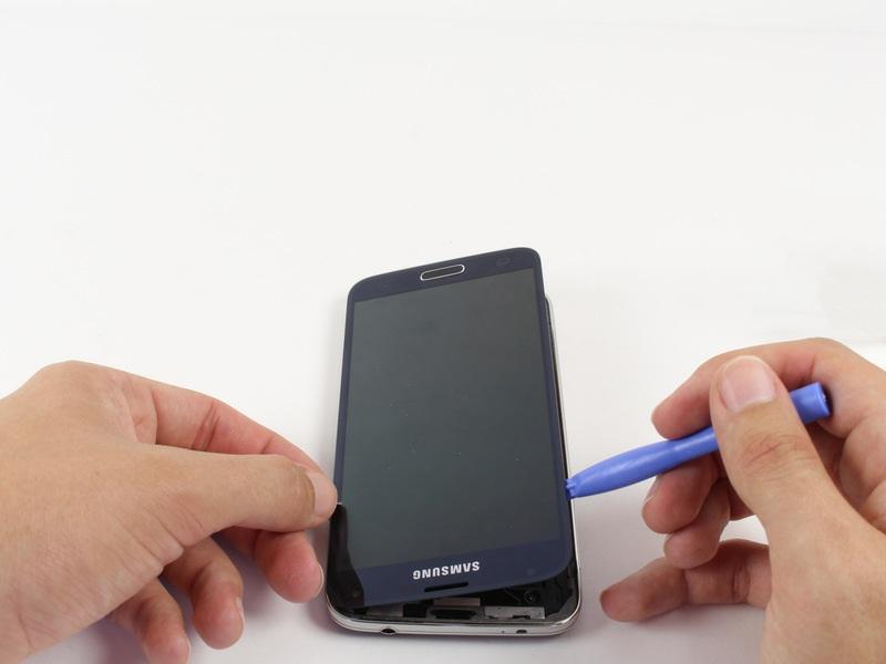 screen off. Starting at the top of the device, work the plastic opening tool under the screen. The top of the device has the Samsung logo and headphone port.