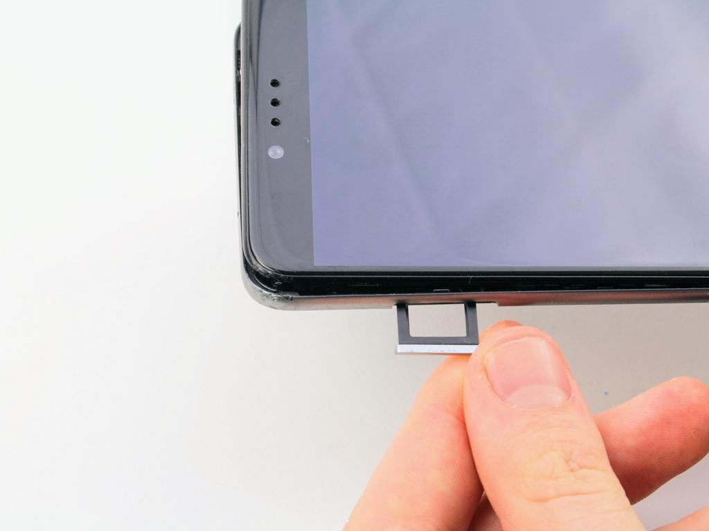 Push down on the plastic opening tool to separate the back panel from the rest of the phone.