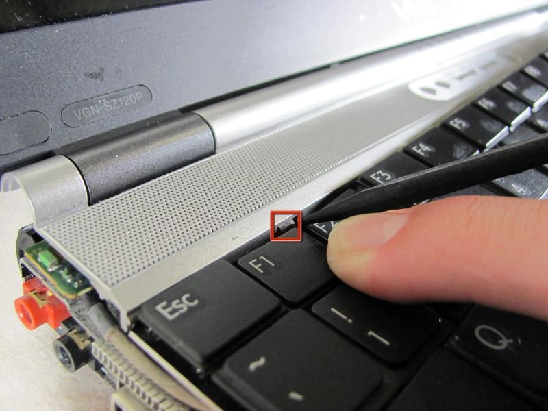 Step 4 Press the tabs on each side of the display-side of the keyboard