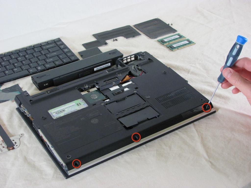 Remove the three screws from the front mouse panel located on the bottom of the laptop.