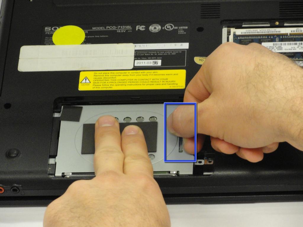 Hold the hard drive securely in a horizontal position using your other hand.