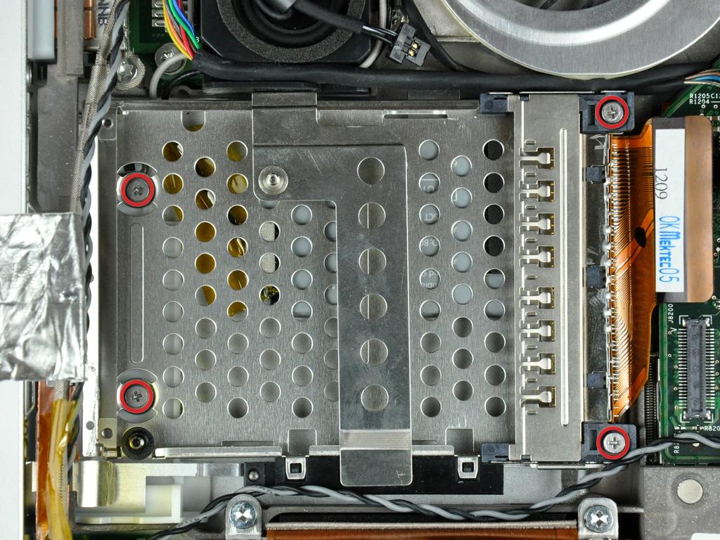 tape off the edge of the PC card cage near the side of the lower case. Remove the four Phillips screws (24 mm & 2-6.