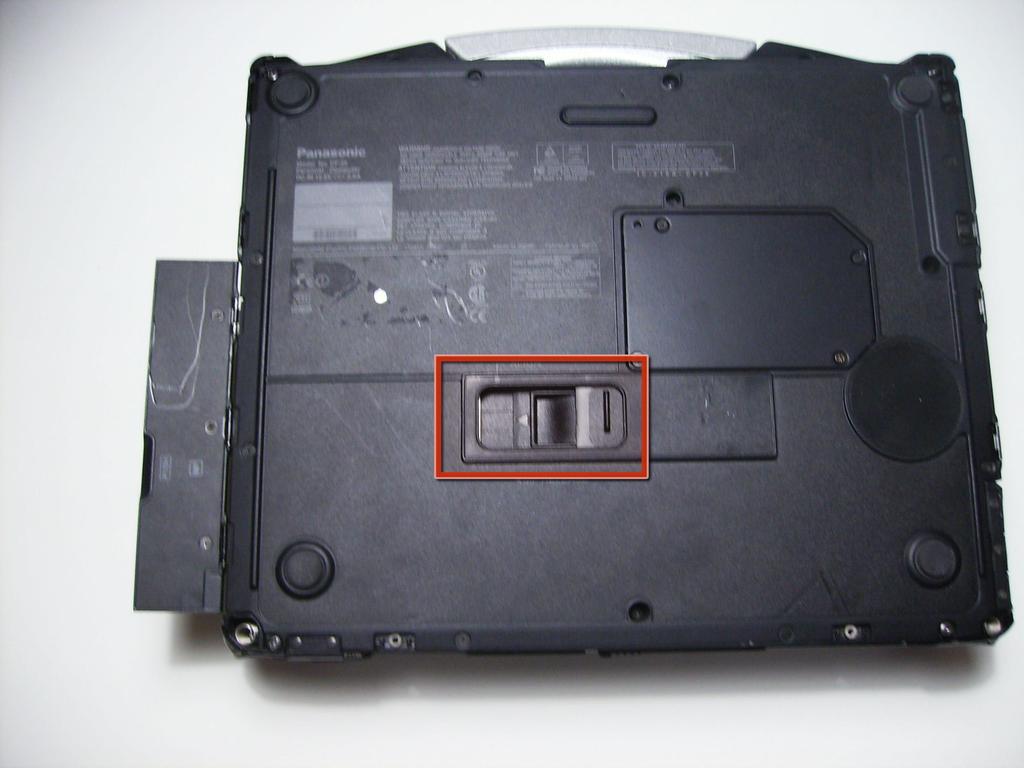 Locate optical drive release mechanism on the bottom of the laptop.