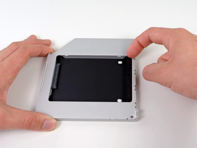 Paso 18 Dual Hard Drive Remove the plastic spacer from the optical bay hard drive enclosure by