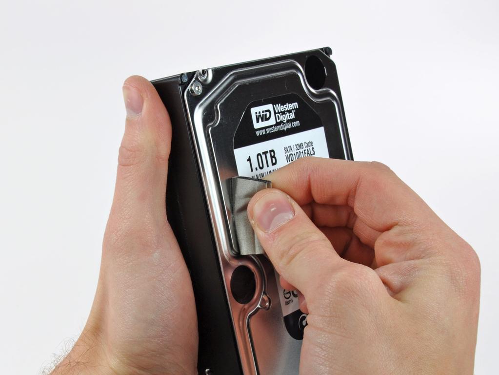 Remove the two T8 Torx pins from the other side of the hard drive.