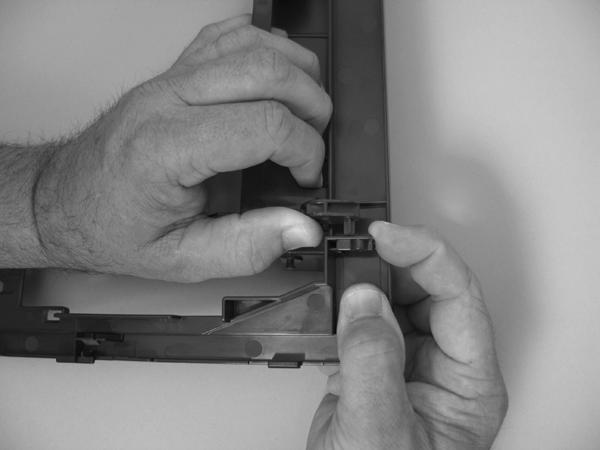 6. Carefully release a feed-guide hinge pin from the rear cover to release