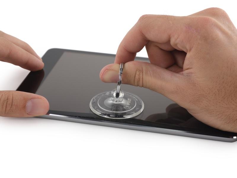 While holding the ipad down with one hand, pull up on the suction cup to slightly separate the front