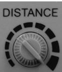 Turn the dial to the left to decrease the distance. The best way to check the effect of the distance setting is to turn the main power switch on the base of the unit to Test.