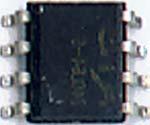 One method of holding the IC in place is to use tweezers. Another method is to apply a dab of contact cement to the bottom of the IC and then position it in place.