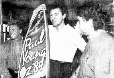 Down Under. Paul Young, center, receives a surfboard from Dennis Handlin, CBS Records' managing director, during his recent Australian concert tour.