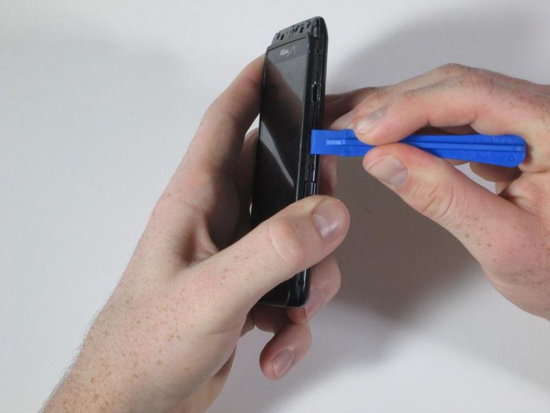Run the plastic opening tool around the edge of the entire device to pry apart the front of the phone