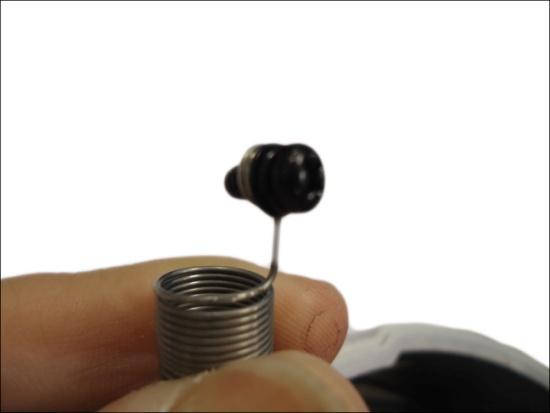 10. Fit the screw into the spring wire that is
