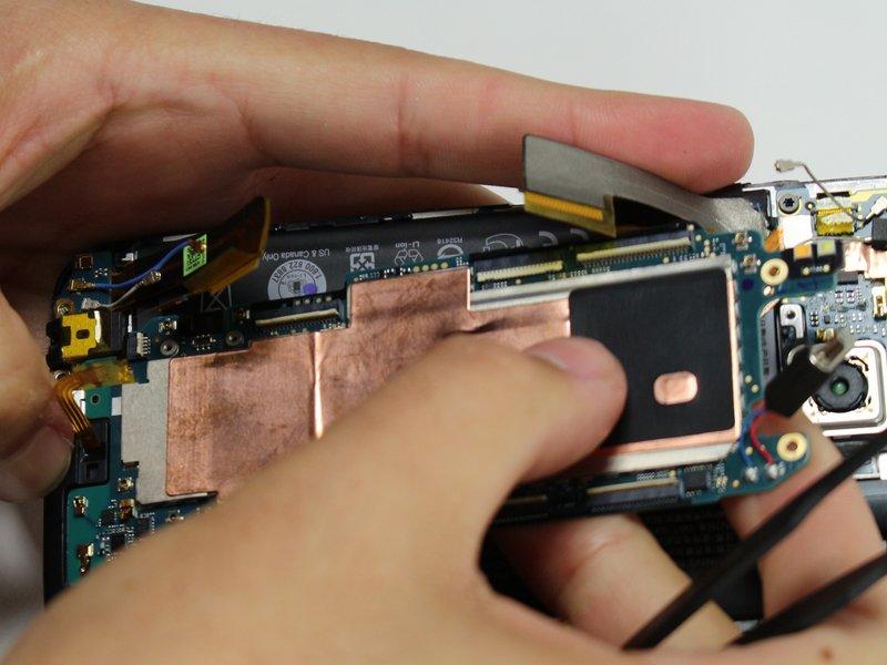 Use a plastic opening tool or a spudger to gently pry the motherboard out of the case. lift first from the top (near the camera).