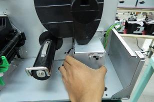 Tilt the Rewinder Assembly forward to avoid the Supply Holder, and place
