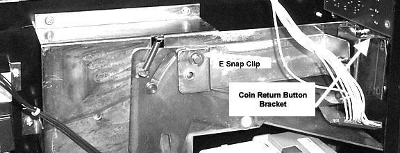 Save E snap clip. Remove four screws retaining the coin-return push button bracket and remove bracket. Save screws.
