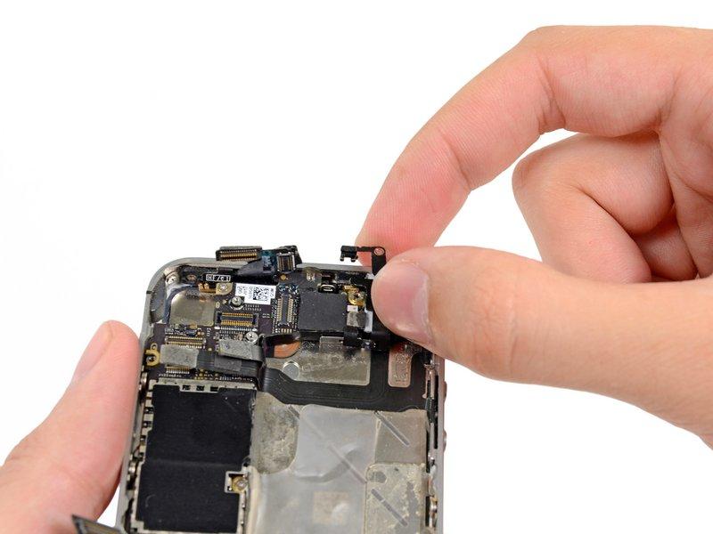 Carefully grasp the grounding clip and remove it from the iphone.